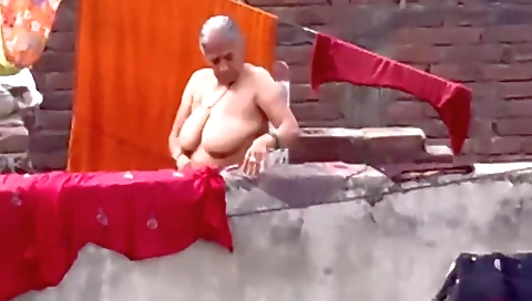Curvy granny is playing with something in the open air